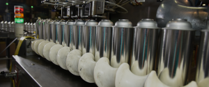 Line of Aerosol Cans Being Filled and Packaged